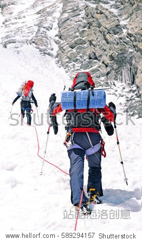 Group of climbers reaches the top of mountain peak. Climbing and mountaineering sport. Teamwork concept.
