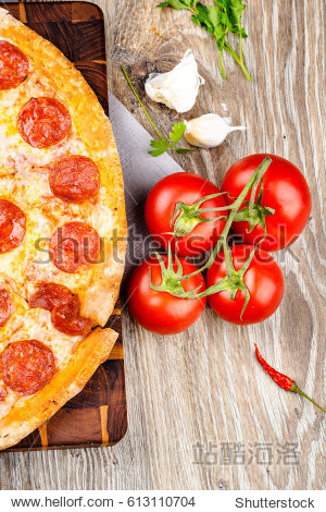 photo of a hot pizza on wooden background.
