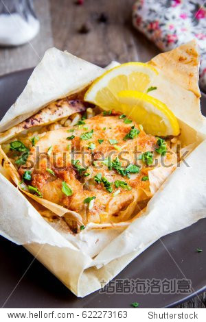white fish fillet baked in parchment with rice and vegetables