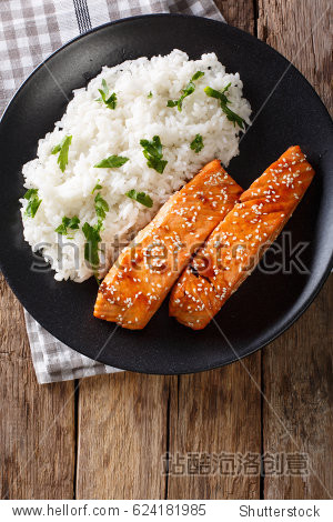glazed salmon fillet with rice garnish close-up on a plate.