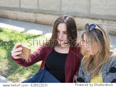 two women take pictures of themselves.