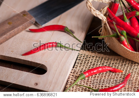 red hot chili peppers in basket on wooden table.