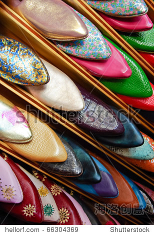 colorful moroccan men silppers aligned on a shoe rack in a shop