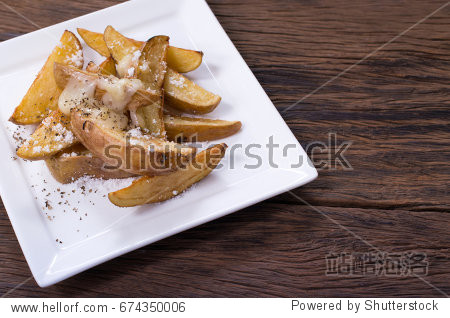 slices of fried potatoes with oregano in a white dish on wooden