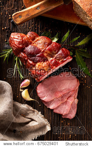 smoked ham sliced on a wooden rustic table with addition of
