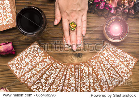 fortune teller female hands and tarot cards on wooden table.