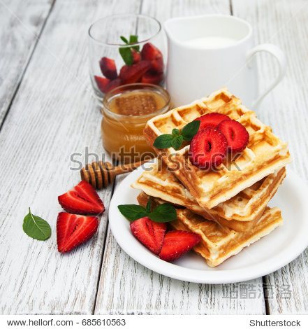 belgian waffles with strawberries and mint with milk on a wooden