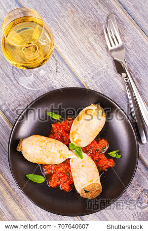 with meat and vegetables in tomato sauce, garnished with mint