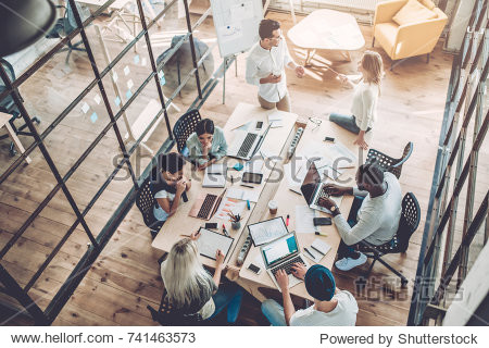 Multiracial young creative people in modern office. Group of young business people are working together with laptop  tablet  smart phone  notebook. Successful hipster team in coworking. Freelancers
