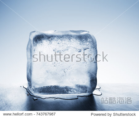 translucent frigid cold blue ice block melting to create pool of