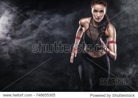 A strong athletic woman sprinter running on black background wearing in the sportswear fitness and sport motivation. Runner concept with copy space.