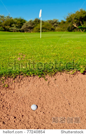 golf ball in a big bunker with trail of ball hitting sand green