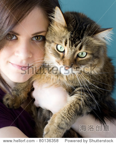 一个年轻女人抱着她的宠物缅因库恩猫.