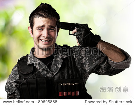 portrait of young soldier committing suicide against a wild