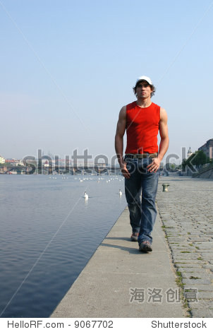 young sexy man walking along the embankment in prague, czech