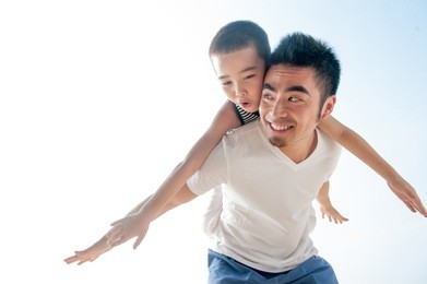 cute asian boy flying on father