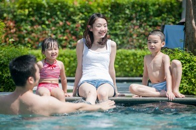 happy asian family playing in the pool