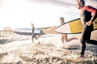 group of friends going to surf at the beach