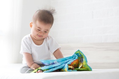 asian baby boy sitting and reading cartoon, 5 month old