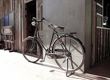 old bicycle leaning against grungy barn
