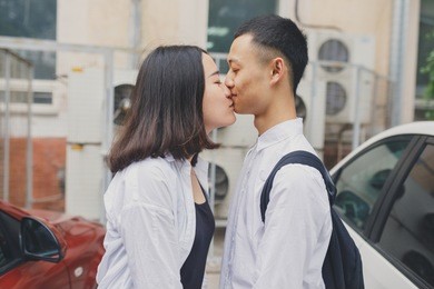 young asian couple walks in the city park. emotional portrait of students. young girl and guy brunette having fun on valentine's day. concept: 14 february