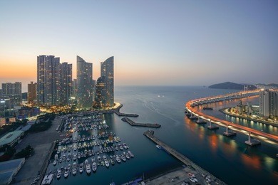 busan city skyline view at haeundae district, gwangalli beach with yacht pier at busan, south korea.