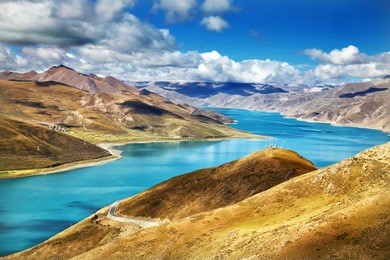 winding river lake in mountains with crystal blue water on sunny blue sky day yamdrok-tso in tibet