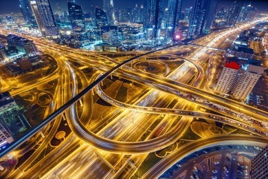 aerial view of big highway interchange with traffic in dubai, uae, at night. scenic cityscape. colorful transportation, communications and driving background.