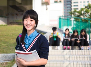 smiling girl teenage students standing  at campus