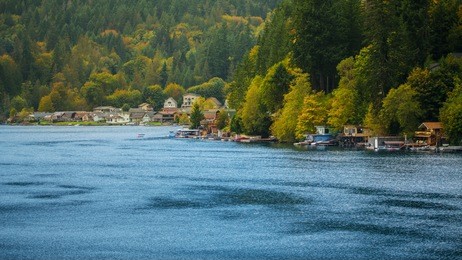 landscape of small houses close to river in the forest in autumn season.