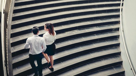 businessman and business woman go up the stairs success concept