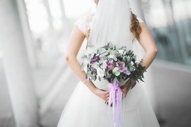 bride holding big and beautiful wedding bouquet with flowers