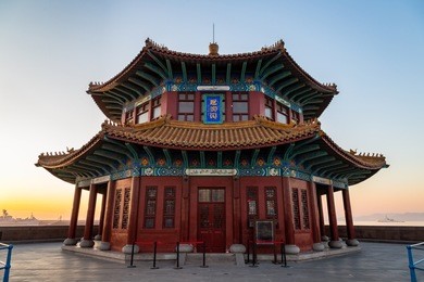 zhanqiao pier at sunrise, qingdao, shandong, china. the name "huilan pavilion" is engraved above the entrance door.