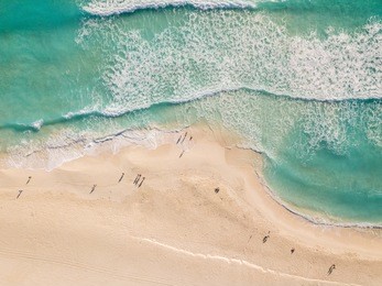 top view of beautiful beach. aerial drone shot of turquoise sea water at the beach - space for text. caribbean seaside beach with turquoise water and big waves aerial view. cancun beach aerial view. 