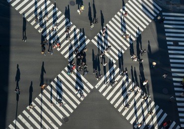 aerial view of people passing crosswalk in the downtown street.