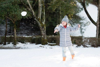little girl throwing snowball