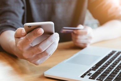 online payment,man's hands holding smartphone and using credit card for online shopping.