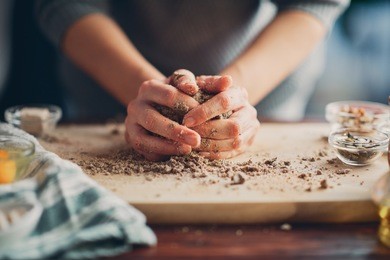close up of woman`s hands making a bread.