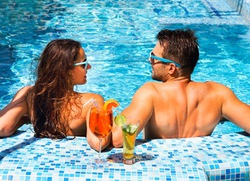 young couple are relaxing at swimming pool party. summer vacation concept