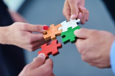 group of business people assembling jigsaw puzzle and represent team support and help concept