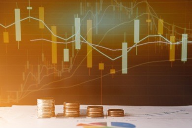 coins stacked growing on financial stock market graph background.