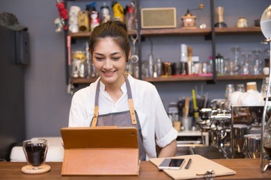 asian barista woman using tablet for promote shop. woman using tablet with attractive smiling.