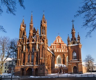 front view of the red brick gothic st. anne's church and bernardine church in the old town of vilnius, lithuania on a winter day.