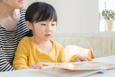japanese little girl reading a story with her mom