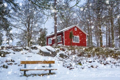 snowy winter scenery with red wooden house in the forest, sweden