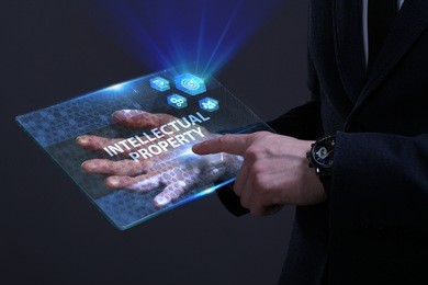 business, technology, internet and network concept. young businessman working on a virtual screen of the future and sees the inscription: intellectual property