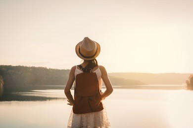 asian girl backpack in nature during sunset , relax time on holiday concept travel,selective and soft focus,color tone of hipster style
