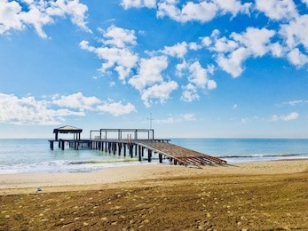 view of the sea and pier at sunset, wide beach, blue sky and wonderful clouds in belek antalya
