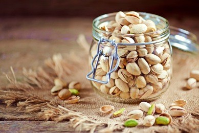 organic pistachios with sea salt in a glass jar. rustic style.