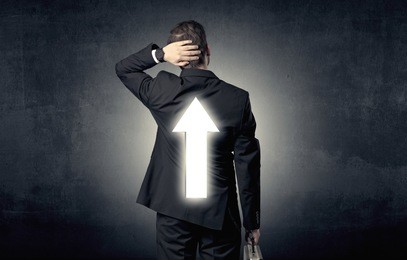 young businessman standing and thinking about which direction to choose